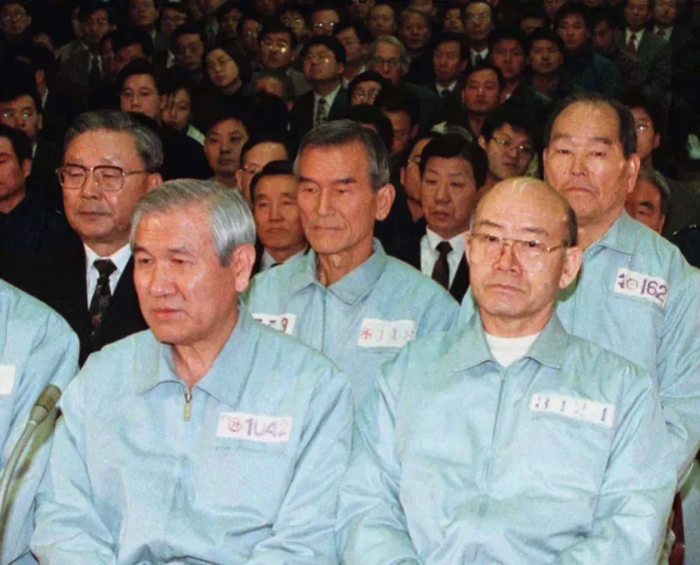 Former South Korean presidents Roh Tae-woo (left) and Chun Doo-hwan (right), dressed in prison uniforms, appearing in court in 1996 to hear a reduction in their original sentences for mutiny, treason and bribery [File: Reuters]
